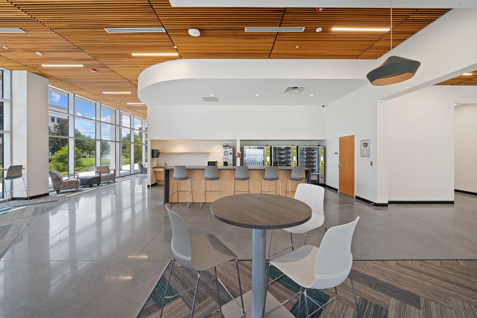 View of a cafeteria counter with refrigerators stocked with drinks in the background